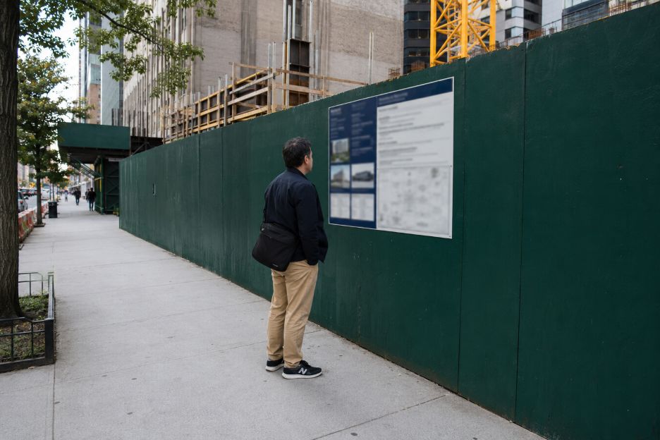 Pedestrian Reading a Manhattan Construction Panel